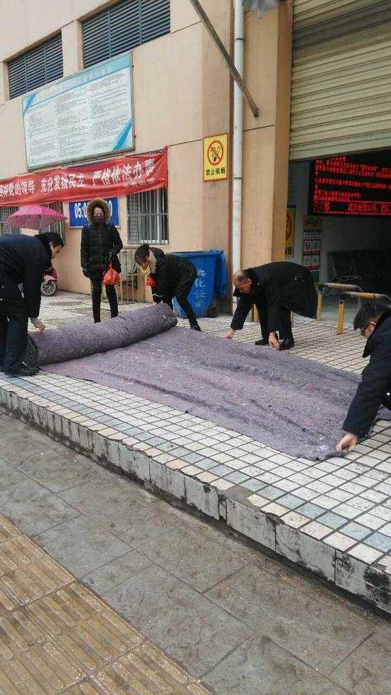 長青城管在農貿市場外鋪上防滑墊